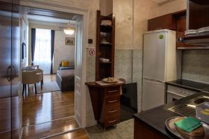 a kitchen with a refrigerator and a living room at Knez Mihailova Apartman in Belgrade