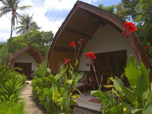 a small house with red flowers in front of it at Chill Out Bungalows in Gili Air