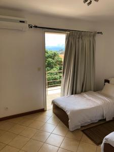 sypialnia z łóżkiem i dużym oknem w obiekcie Center Point w mieście Antsiranana