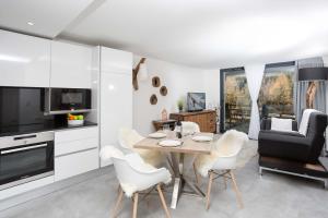 cocina y comedor con mesa y sillas en La Cordee 412 Apartment - Chamonix All Year en Chamonix-Mont-Blanc