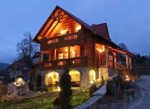a large wooden house with lights on at Медовий in Vorokhta