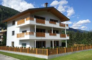 a large white building with wooden balconies on it at Villa Aylin in Prato alla Drava