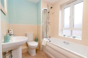 a bathroom with a toilet and a sink and a bath tub at Central 2 bedroom apartment in Basingstoke