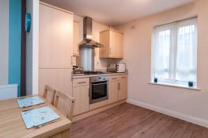 a kitchen with a table and a stove top oven at Central 2 bedroom apartment in Basingstoke