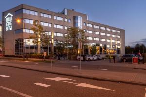 un grand bâtiment avec des voitures garées devant lui dans l'établissement Urban Lodge Hotel, à Amsterdam