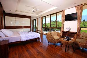 a bedroom with a bed and a table and chairs at Chateau Woods in Kalpetta