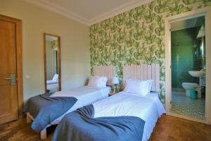 two beds sitting in a room with a bathroom at Nice Way Cascais Hostel & Surf Camp in Cascais