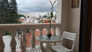 una mesa y sillas en un balcón con vistas en Departamento España en Salta