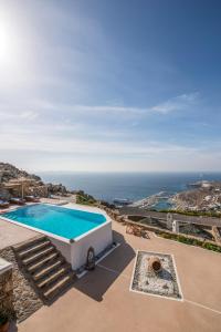a villa with a swimming pool and the ocean at Manolia View Mykonos in Tourlos