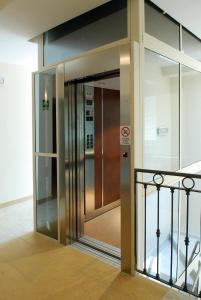 um elevador num edifício com uma porta de vidro em Residence Pax em Fiumaretta di Ameglia