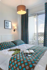 a bedroom with a bed with two books on it at Résidence Néméa Les Balcons des Pêcheurs in Mimizan-Plage