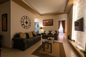 Una sala de estar con sofás y un reloj en la pared. en Giulio Cesare Imperatore, en Roma