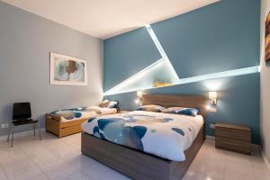 Un dormitorio con dos camas y una pared azul. en Giulio Cesare Imperatore, en Roma