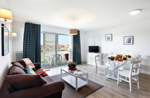 a living room with a couch and a table at Résidence Goélia Les Balcons des Pêcheurs in Mimizan-Plage