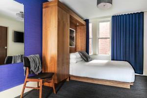1 dormitorio con 1 cama y 1 silla en una habitación en Found Hotel Boston Common en Boston