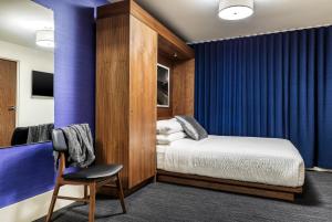 ボストンにあるファウンド ホテル ボストン コモンのベッドルーム1室(ベッド1台、椅子付)