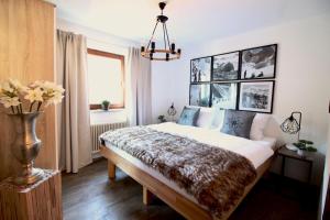 een slaapkamer met een bed en een vaas met bloemen bij BELLE KITZ im Zentrum by Belle Stay in Kitzbühel