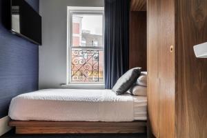 
a bed sitting in a bedroom next to a window at Found Hotel Boston Common in Boston
