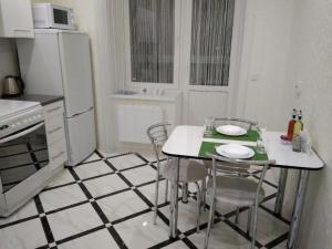 a kitchen with a table and chairs and a refrigerator at PaulMarieApartments on Beloborodova in Vitebsk