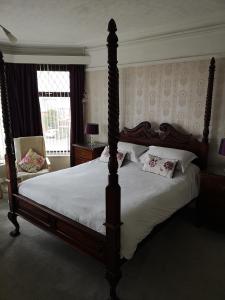 a bedroom with a large bed with white sheets at East Mount House in Barrow in Furness