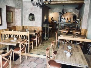 a restaurant with wooden tables and chairs in a room at Atmosféra Rooms & Restaurant in Loket
