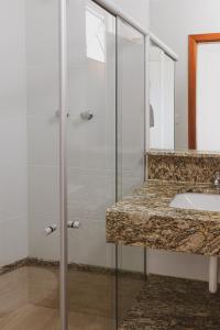 uma casa de banho com uma cabina de duche em vidro e um lavatório. em Star Apart Hotel em Teófilo Otoni