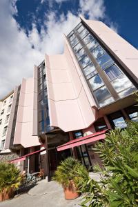 un edificio de oficinas con una fachada rosa en The Originals Boutique, Hôtel Montélimar, en Montélimar