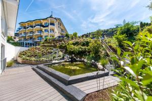 a garden with a pond in front of a building at Moselromantik Hotel Kessler Meyer in Cochem