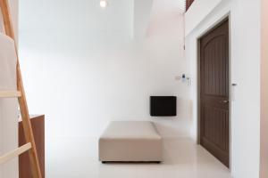 a white room with a bed and a door at Barayan place in Na Jomtien