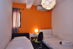 Cette chambre comprend deux lits et un bureau avec une lampe. dans l'établissement City Living Suite TK 1 Rm 3, à San Ġiljan