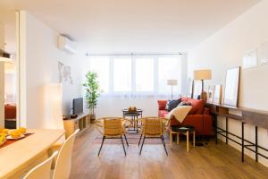 a living room with a couch and a table and chairs at Amazing City Center 2 bdr flat! in Lisbon