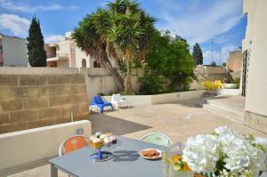 - une table avec de la nourriture et des fleurs sur la terrasse dans l'établissement City Living Suite TK 1 Rm 3, à San Ġiljan
