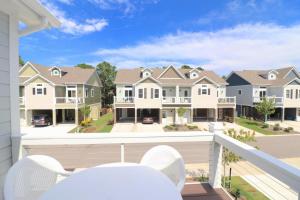 a balcony with white chairs and houses at Beacon Villas at Corolla Light Resort by KEES Vacations in Corolla