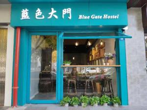 Suzhou Blue Gate Youth Hostel في سوتشو: منزل من البوابة الزرقاء مع النباتات في النافذة
