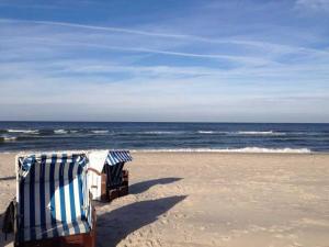オストゼーバート・ディアーハーゲンにあるDUENENBLICK App Nr 4 max 4 Persのビーチの砂の上に座るビーチチェア2脚