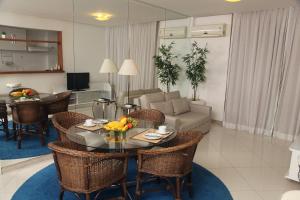 een woonkamer met een tafel en stoelen en een bank bij KS Residence in Rio de Janeiro