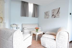 a living room with two chairs and a table at Hotel Risi in Colico