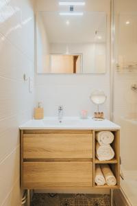 bagno con lavandino e specchio di Le Charme des 2 Lacs a Malbuisson