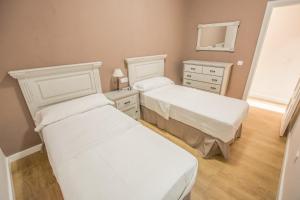 1 dormitorio con 2 camas, tocador y espejo en Apartamento Plaza Mayor Cáceres, en Cáceres