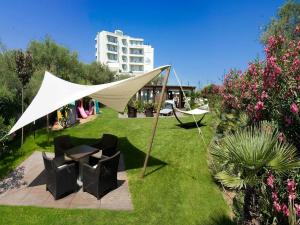 a tent with chairs and a table in the grass at Hotel Sarti in Riccione