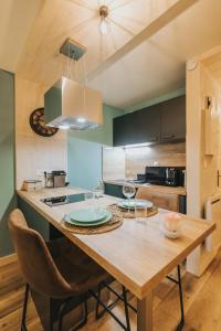 a kitchen with a wooden table with glasses on it at Le Charme des 2 Lacs in Malbuisson