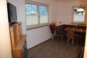 a living room with a dining room table and a television at Haus Markus in Fügen
