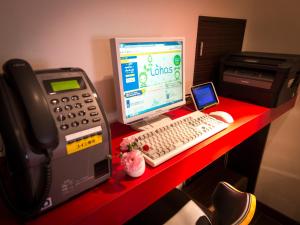 a desk with a desktop computer and a phone at Super Hotel Tokyo Akabane in Tokyo