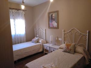 - une chambre avec 2 lits et une fenêtre dans l'établissement Casa Rural La Santiaga, à Arroyo de la Luz