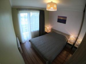 a bedroom with a bed and a large window at Lavander suite in Ventspils