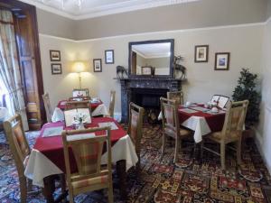 a dining room with two tables and a fireplace at Glendale Guest House in Penrith