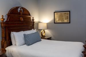 a bed with a white comforter and pillows at East Bay Inn, Historic Inns of Savannah Collection in Savannah