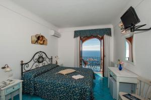 a bedroom with a bed and a tv at Hotel Il Gabbiano in Positano