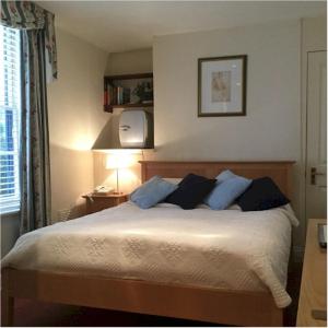a bedroom with a large bed with blue pillows at Bath Place Hotel in Oxford