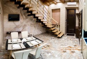 ein Esszimmer mit einer Treppe, einem Tisch und Stühlen in der Unterkunft Apartments "The cultural capital" VIP in Lwiw